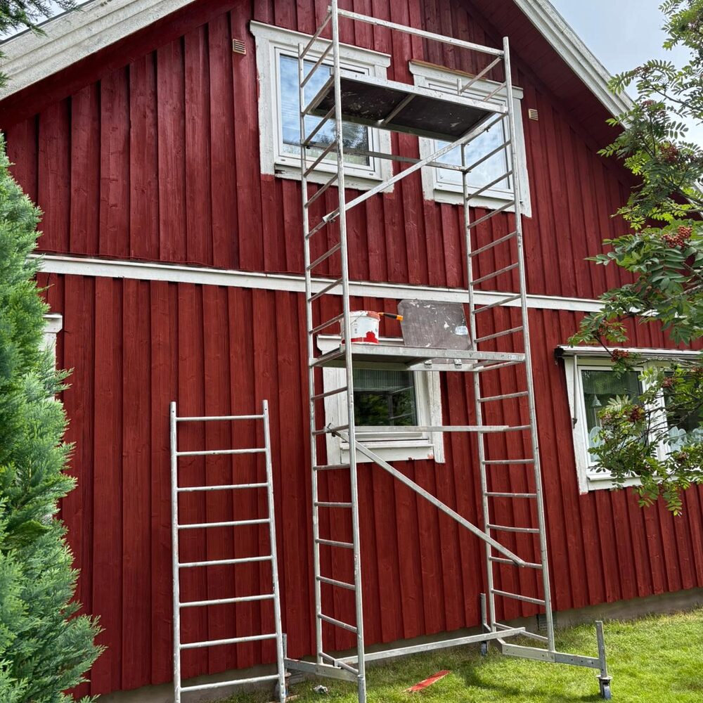 Fasadmålning — röd träfasad med ställning